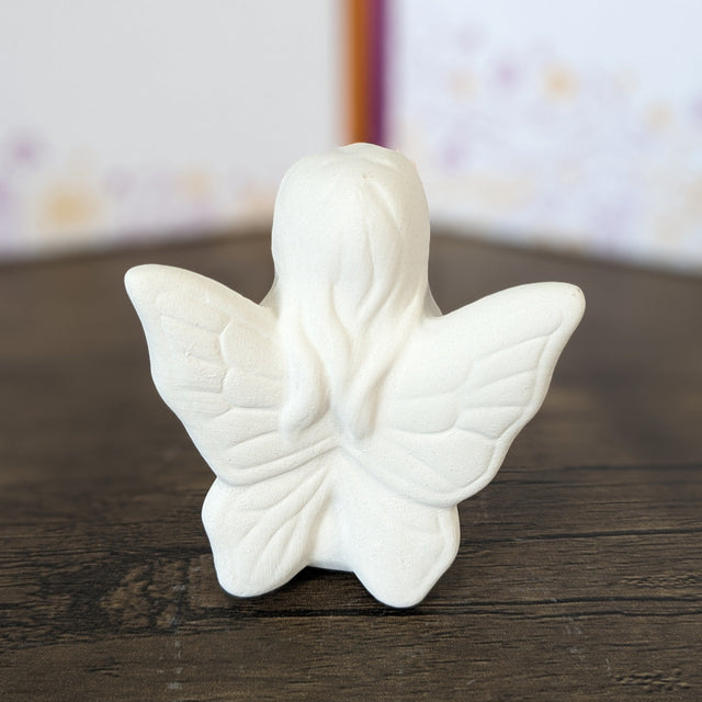 Unpainted pottery bisque seated small fairy, back view